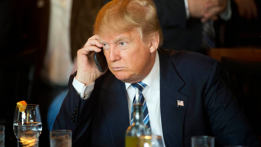 Republican presidential candidate Donald Trump listens to his mobile phone during a lunch stop, Feb. 18, 2016, in North Charleston, S.C. (Photo by Matt Rourke/AP)