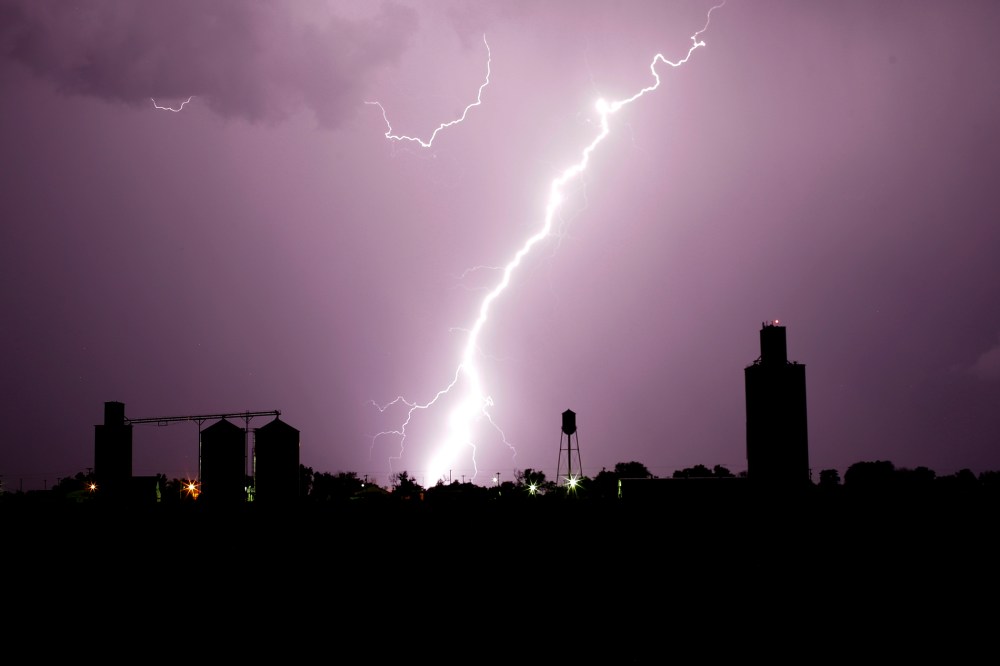 Grain elevators are silhouetted against lightning as a thunderstorm passes in the distance, June 4, 2015, in Collyer, Kan. (Photo by Charlie Riedel/AP)
