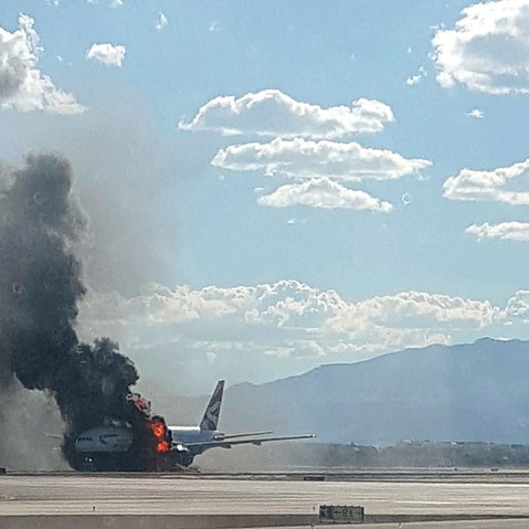 Smoke billows out from a plane that caught fire at McCarren International Airport on Sept. 8, 2015, in Las Vegas, Nev. (Photo by Eric Hays/AP)