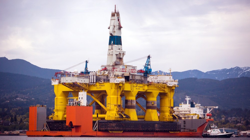 The Polar Pioneer oil drilling rig arrives aboard a transport ship, following a journey across the Pacific, in view of the Olympic Mountains in Port Angeles, Wash. on April 17, 2015. (Photo by Daniella Beccaria/seattlepi.com/File/AP)