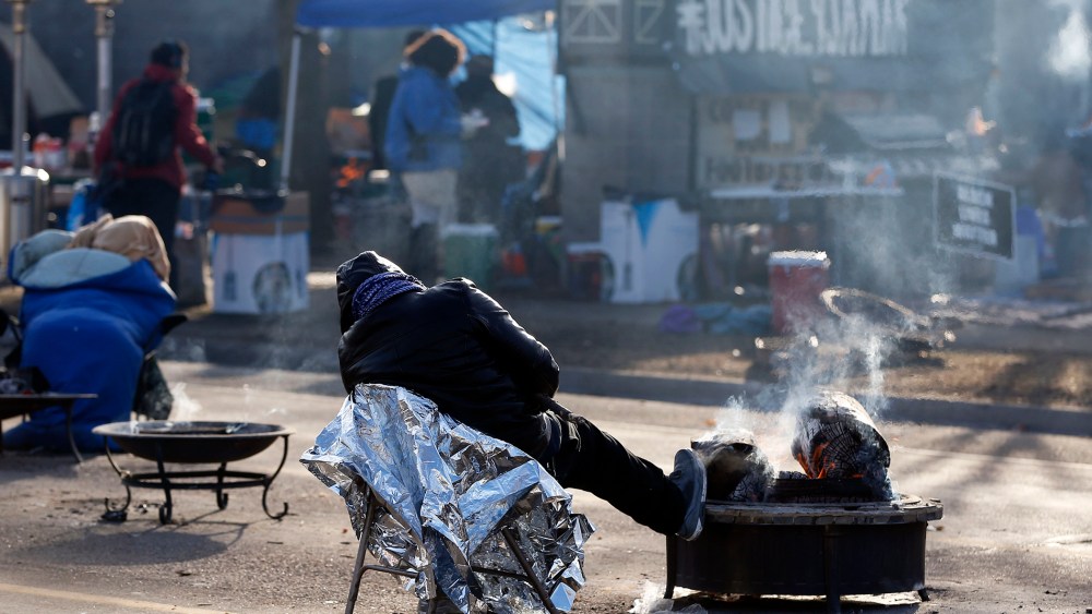 A protester gets some rest at the Black Lives Matter encampment, Tuesday, Nov. 24, 2015, outside the Minneapolis Police Department's Fourth Precinct in Minneapolis. (Photo by Jim Mone/AP)
