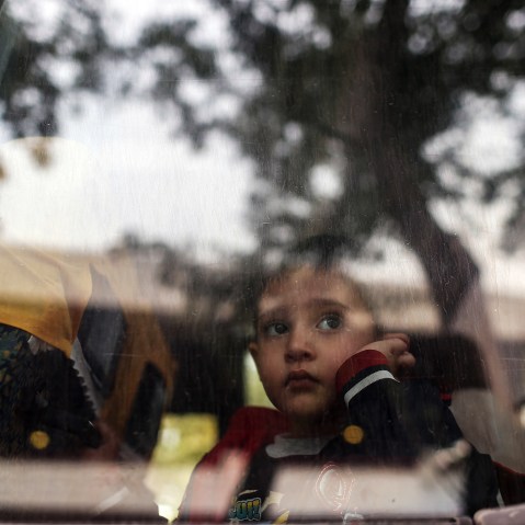A refugee child looks through a bus window as they leave for Istanbul, abandoning plans to cross to Europe near Turkey's western border with Greece and Bulgaria, in Edirne, Turkey, Sept. 23, 2015. (Photo by Emrah Gurel/AP)
