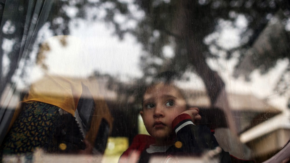 A refugee child looks through a bus window as they leave for Istanbul, abandoning plans to cross to Europe near Turkey's western border with Greece and Bulgaria, in Edirne, Turkey, Sept. 23, 2015. (Photo by Emrah Gurel/AP)