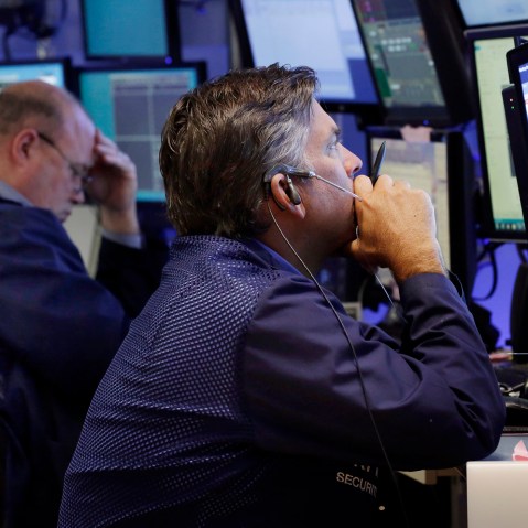 Traders work in a booth on the floor of the New York Stock Exchange, Aug. 24, 2015. (Photo by Richard Drew/AP)