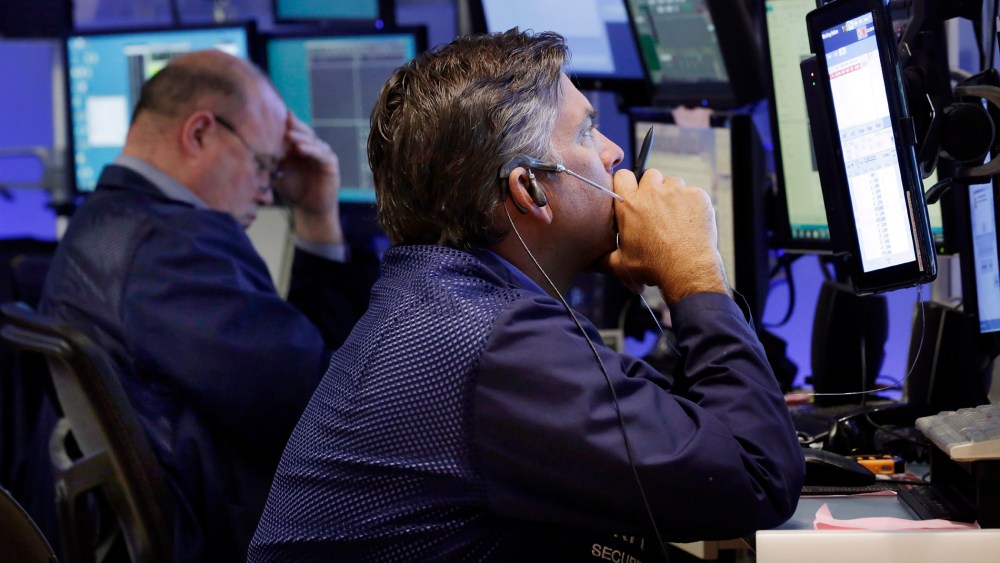 Traders work in a booth on the floor of the New York Stock Exchange, Aug. 24, 2015. (Photo by Richard Drew/AP)