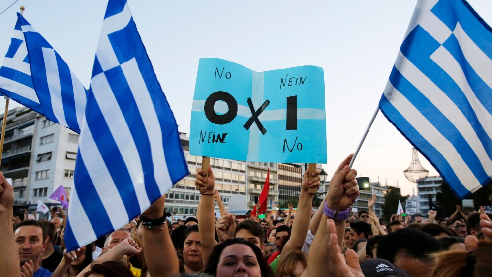 A demonstrator holds a placard reading in Greek, German and English the word ''NO'' during a rally organized by supporters of the No vote in Athens on July 3, 2015. (Photo by Petros Karadjias/AP)