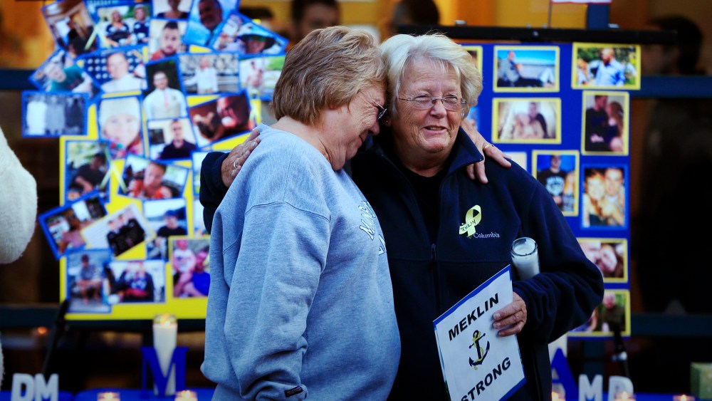 Deborah Dyer, right, is hugged by Judy Marzolf at vigil held at Maine Maritime Academy for the missing crew members of the U.S. container ship El Faro, Oct. 6, 2015, in Castine, Maine. (Photo by Robert F. Bukaty/AP)