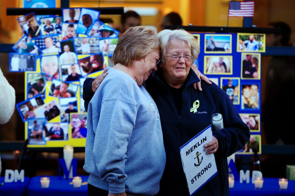 Deborah Dyer, right, is hugged by Judy Marzolf at vigil held at Maine Maritime Academy for the missing crew members of the U.S. container ship El Faro, Oct. 6, 2015, in Castine, Maine. (Photo by Robert F. Bukaty/AP)