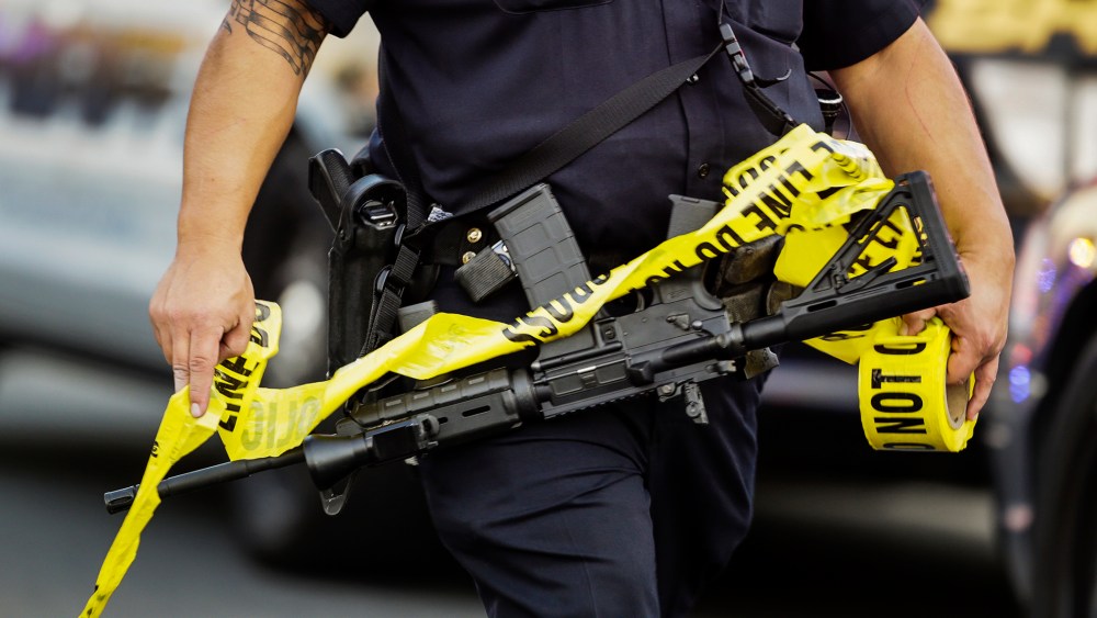 A police officer deploys tape to an area near where authorities stopped a vehicle in San Bernardino, Calif., Dec. 2, 2015. (Photo by Damian Dovarganes/AP)