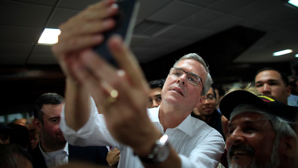 Former Florida Gov. Jeb Bush takes a selfie with a supporter's phone in Bayamon, Puerto Rico, Tuesday, April 28, 2015. (Photo by Ricardo Arduengo/AP)