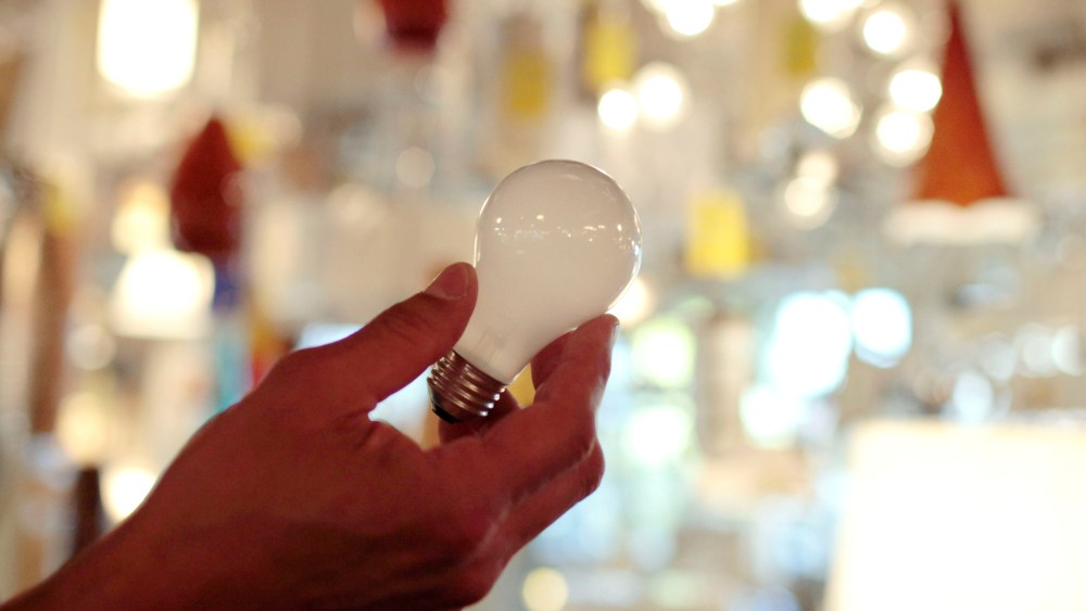 In this Jan. 21, 2011, file photo, Manager Nick Reynoza holds a 100-watt incandescent light bulb at Royal Lighting in Los Angeles.