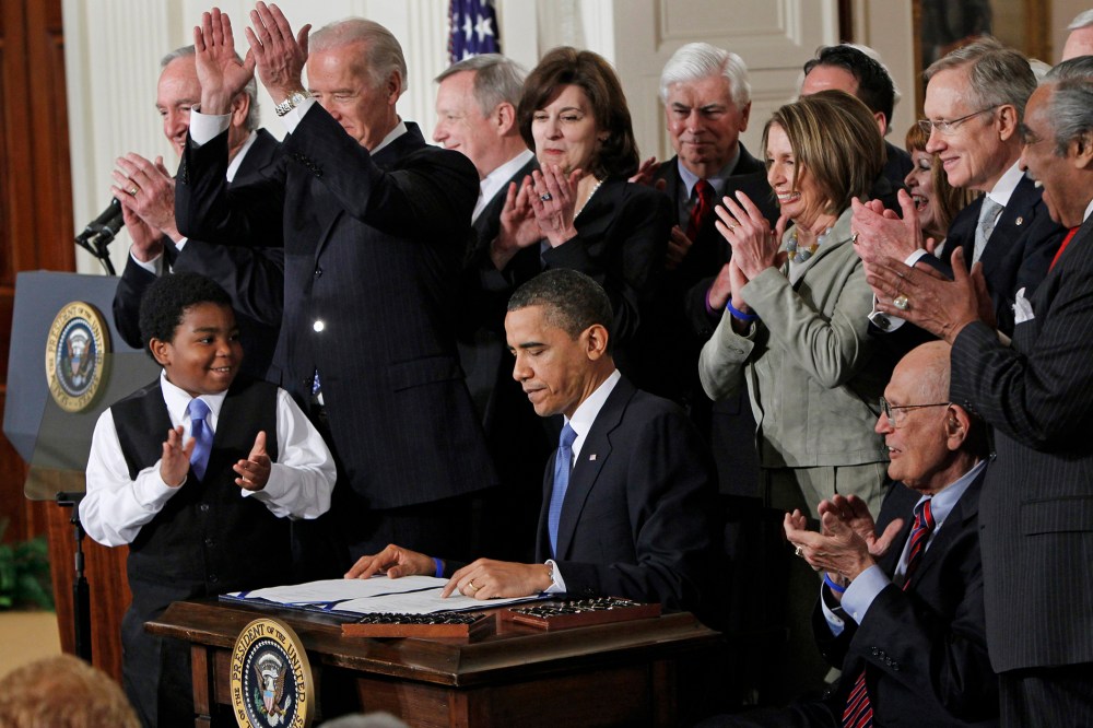 In this March 23, 2010, file photo, President Barack Obama is applauded after signing the Affordable Care Act into law in the East Room of the White House in Washington. (Photo by Charles Dharapak/AP)