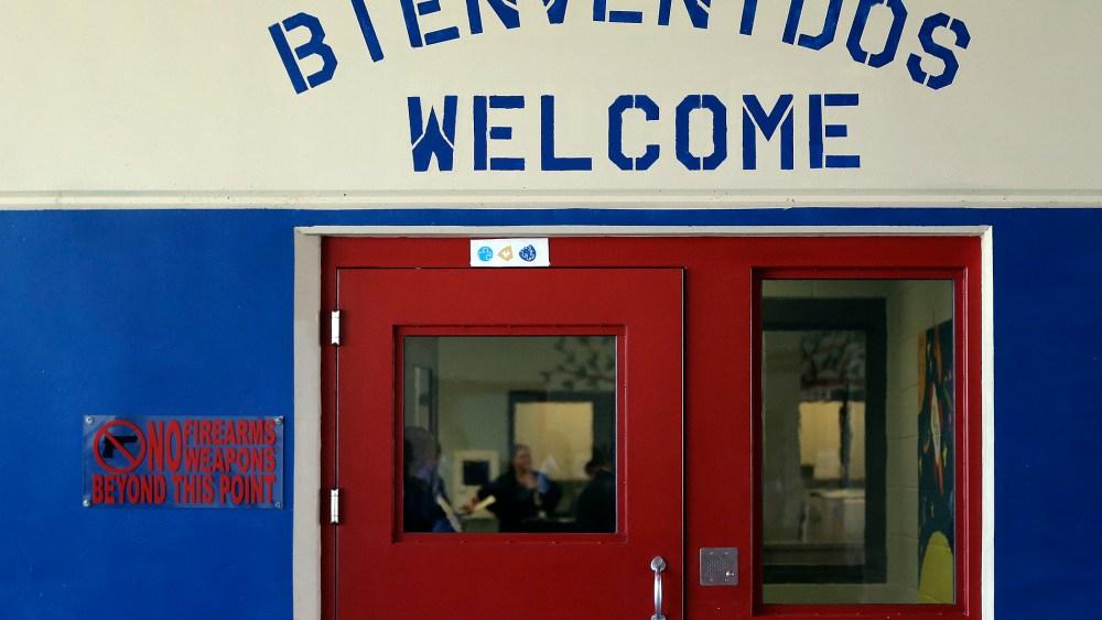 A Spanish and English welcome sign is seen above a door in a secured entrance area at the Karnes County Residential Center in Karnes City, Texas on Jul. 31, 2014.