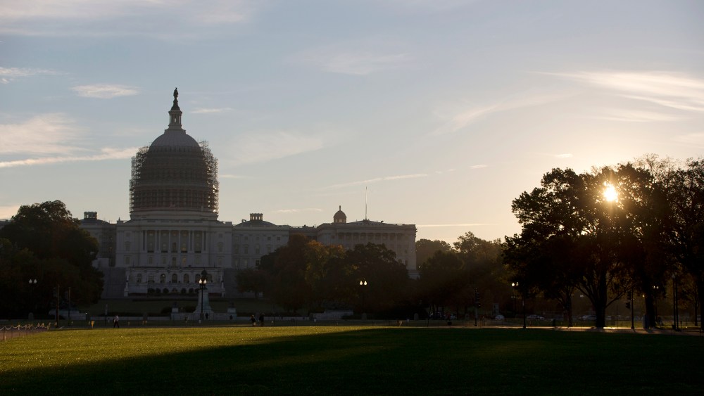 The sun rises behind the U.S. Capitol Building grounds in Washington, D.C., Oct. 20, 2014. (Photo by Carolyn Kaster/AP)
