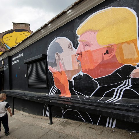 A child walks past a graffiti depicting Russian President Vladimir Putin and Republican presidential candidate Donald Trump on the walls of a bar in the old town in Vilnius, Lithuania, May 14, 2016. (Photo by Mindaugas Kulbis/AP)
