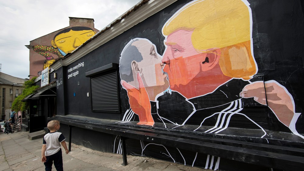 A child walks past a graffiti depicting Russian President Vladimir Putin and Republican presidential candidate Donald Trump on the walls of a bar in the old town in Vilnius, Lithuania, May 14, 2016. (Photo by Mindaugas Kulbis/AP)