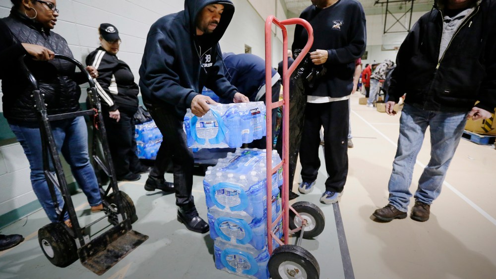 Will Burnett helps load a cart with bottled water at the Salvation Army Flint Beecher Corps Community Center in Flint, Mich., Jan. 26, 2016. (Photo by Carlos Osorio/AP)