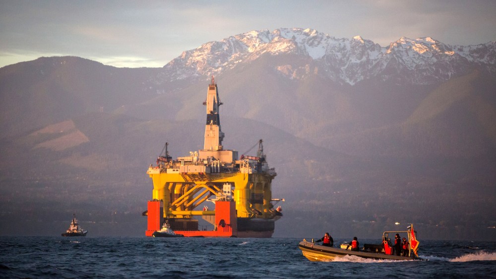 A small boat crosses in front of an oil drilling rig as it arrives in Port Angeles, Wash. on April 17, 2015. (Photo by Daniella Beccaria/seattlepi.com/File/AP)