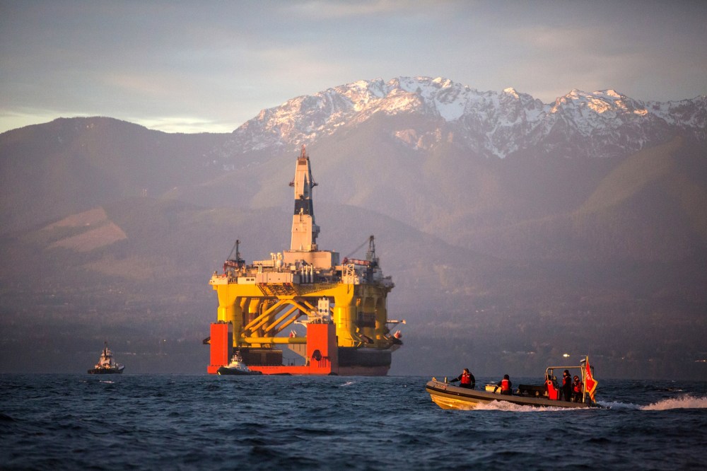 A small boat crosses in front of an oil drilling rig as it arrives in Port Angeles, Wash. on April 17, 2015. (Photo by Daniella Beccaria/seattlepi.com/File/AP)