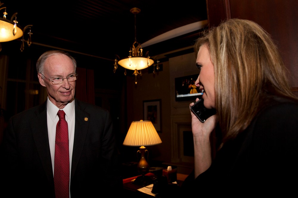 In this Tuesday, Nov. 4, 2014 file photo, Republican Gov. Robert Bentley listens to a phone call as Rebekah Mason, right, announces his win for Alabama governor, in Montgomery, Ala. (Photo by Brynn Anderson/AP)
