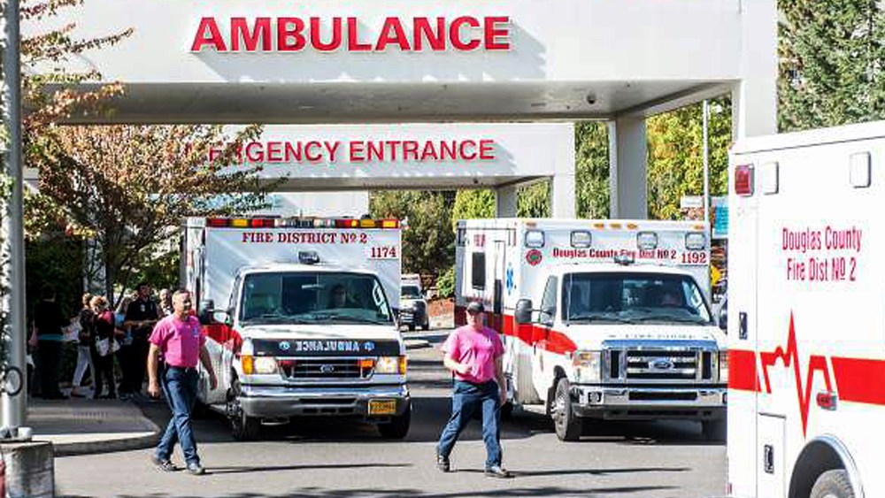 Paramedics return to their ambulances after delivering patients to Mercy Medical Center in Roseburg, Ore., following a deadly shooting at Umpqua Community College, in Roseburg, Oct. 1, 2015. (Photo by Aaron Yost/Roseburg News-Review/AP)