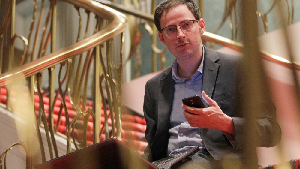Nate Silver holds his phone as he sits on the stairs with his laptop computer at a hotel in Chicago on Nov. 9, 2012. (Photo by Nam Y. Huh/AP)