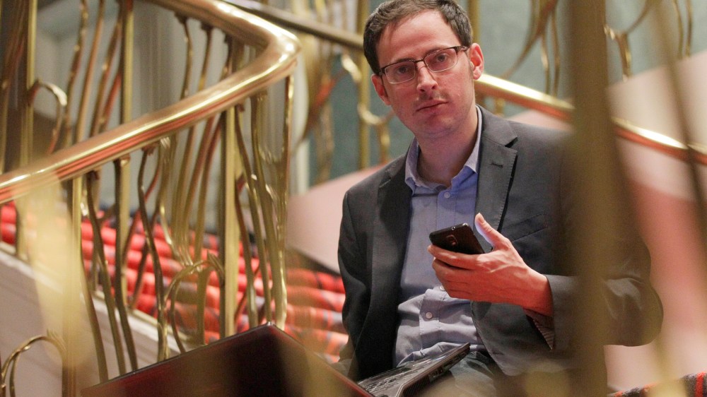 Nate Silver holds his phone as he sits on the stairs with his laptop computer at a hotel in Chicago on Nov. 9, 2012. (Photo by Nam Y. Huh/AP)