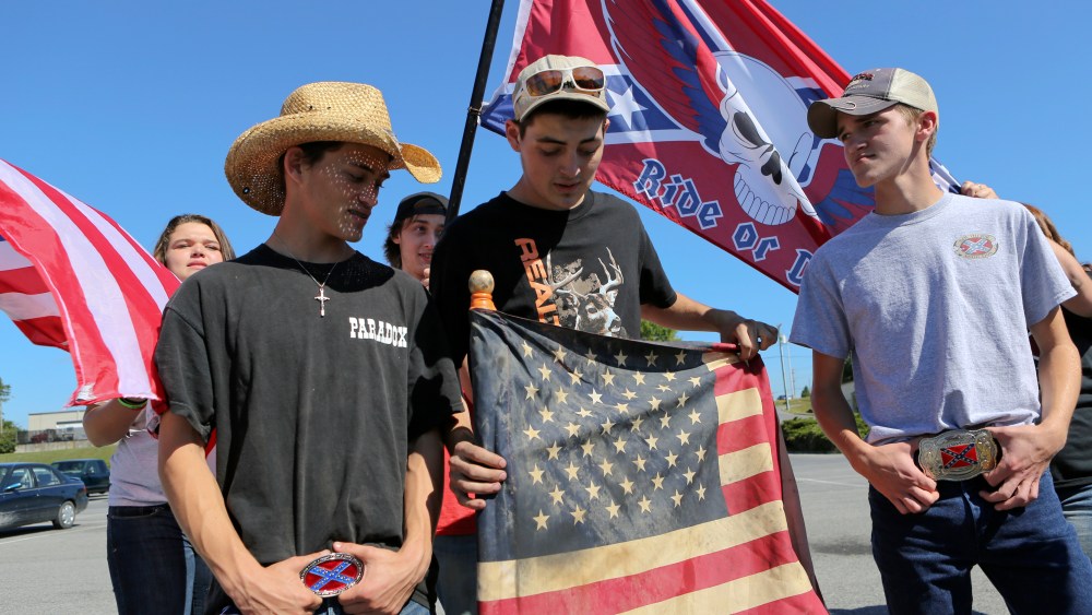 Christiansburg High School students bearing American and Confederate flags gather in a shopping center parking lot after being suspended from school property in Christiansburg, Va. on Sept. 17, 2015. (Photo by Matt Gentry/The Roanoke Times/AP)