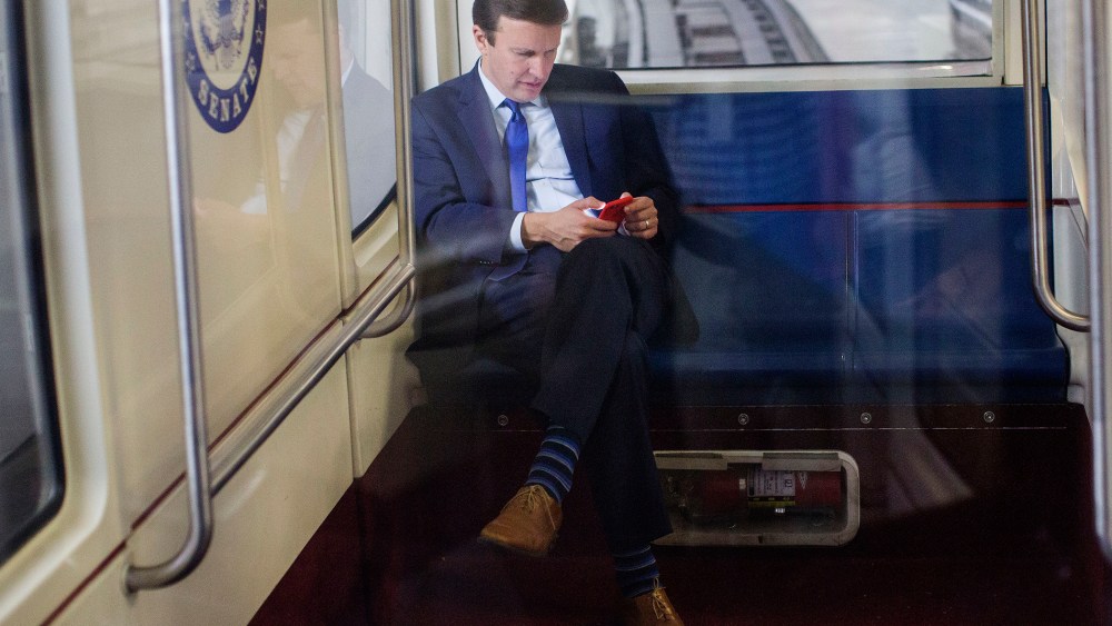 Sen. Chris Murphy, D-Conn., uses his cell phone as he rides the Senate subway in Washington, D.C., Dec. 1, 2015. (Photo By Al Drago/CQ Roll Call/AP)