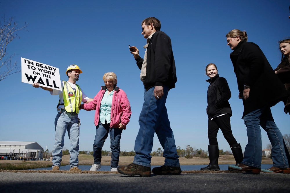 Bill Waters displays a placard as people approach a campaign stop for Republican presidential candidate Donald Trump, Feb. 19, 2016, in Myrtle Beach, S.C. (Photo by Matt Rourke/AP)
