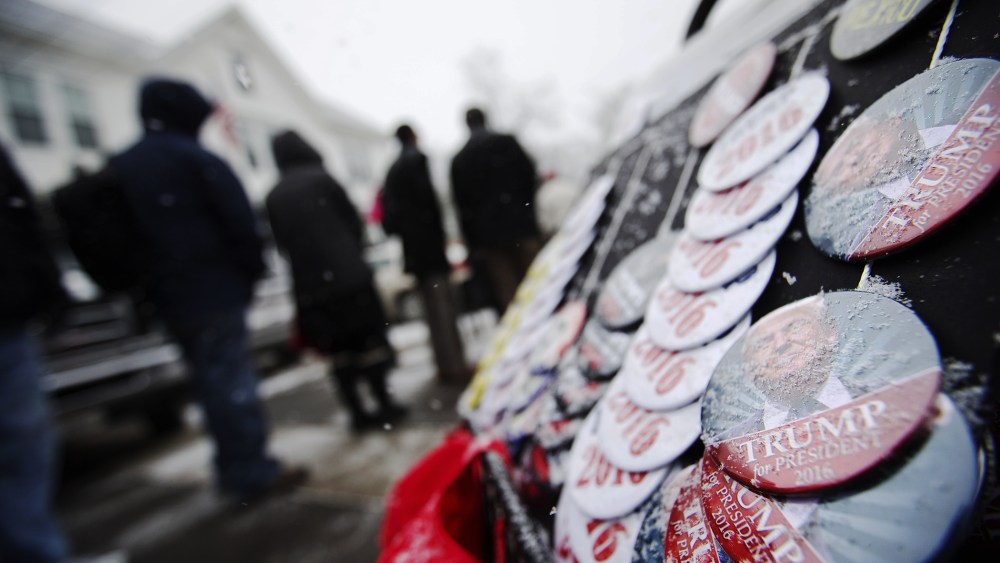 Snow collects on buttons for sale outside a campaign event for Republican presidential candidate Donald Trump at the Londonderry Lions Club, Feb. 8, 2016, in Londonderry, N.H. (Photo by David Goldman/AP)