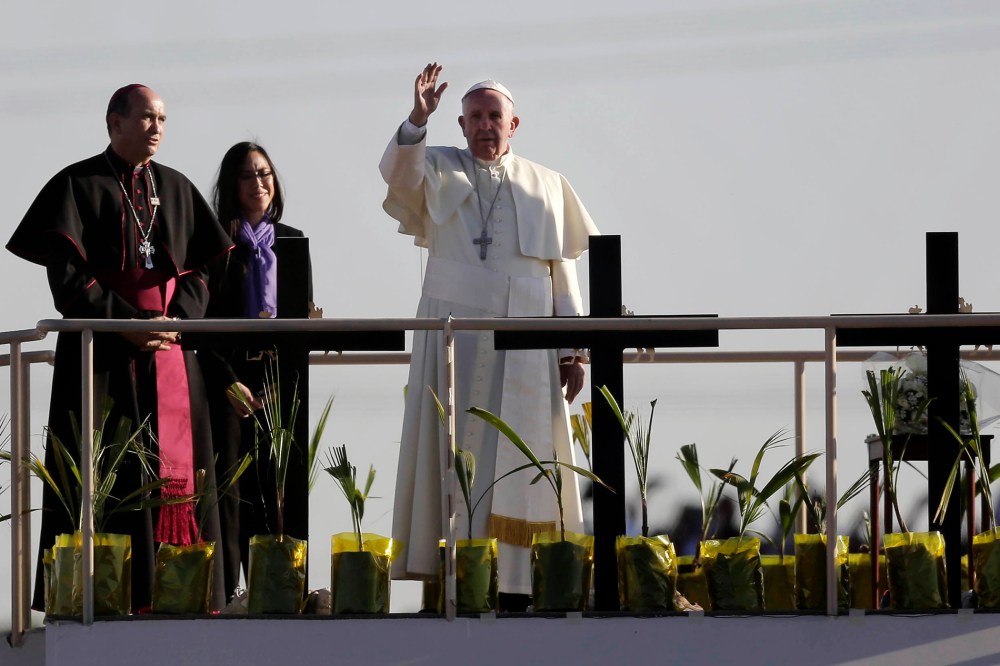 Pope Francis stands on a platform near the U.S.-Mexico border fence along the Rio Grande, in Ciudad Juarez, Mexico, Feb. 17, 2016, as he blesses a group of migrants. (Photo by Eric Gay/AP)