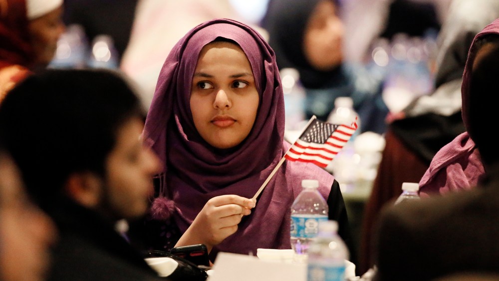 A young woman waves an American flag along with others at the beginning of a Muslim conference against terror and hate at the Curtis Culwell Center, Saturday, Jan. 17, 2015, in Garland, Tex. (Photo by Tony Gutierrez/AP)