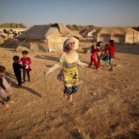 Syrian refugee girl, Zubaida Faisal, 10, skips a rope while she and other children play near their tents at an informal tented settlement near the Syrian border on the outskirts of Mafraq, Jordan, July 19, 2015. (Photo by Muhammed Muheisen/AP)