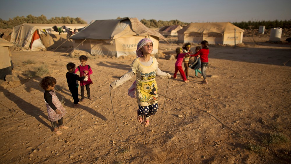 Syrian refugee girl, Zubaida Faisal, 10, skips a rope while she and other children play near their tents at an informal tented settlement near the Syrian border on the outskirts of Mafraq, Jordan, July 19, 2015. (Photo by Muhammed Muheisen/AP)
