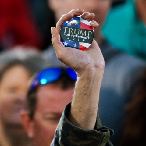 A man holds up a campaign button for Republican presidential candidate Donald Trump during a rally, Feb. 28, 2016, in Madison, Ala. (Photo by John Bazemore/AP)