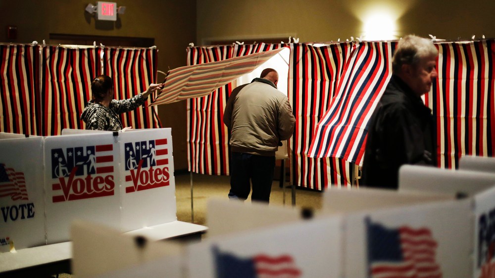A voter steps into a voting booth to mark his ballot at a polling site for the New Hampshire primary, Feb. 9, 2016, in Nashua, N.H. (Photo by David Goldman/AP)