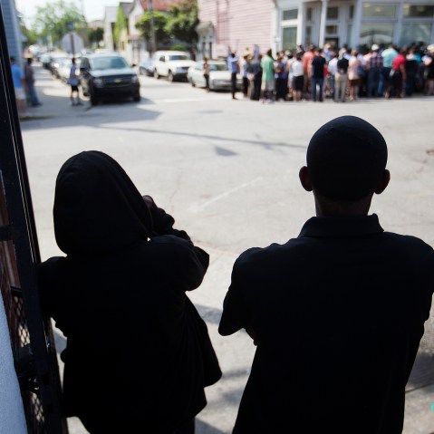 A couple watch from across the street during a news conference outside the Charleston NAACP office regarding the shooting death of Walter Scott by a North Charleston police officer, Thursday, April 9, 2015. (Photo by David Goldman/AP)