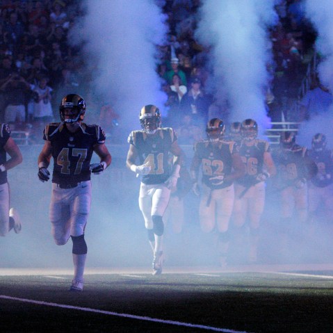 In this Aug. 16, 2014 file photo, members of the St. Louis Rams run onto the field before the start of an NFL football game in St. Louis, Mo. (Photo by Scott Kane/AP)