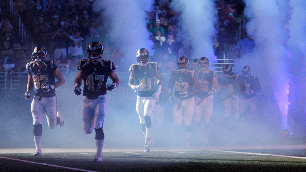 In this Aug. 16, 2014 file photo, members of the St. Louis Rams run onto the field before the start of an NFL football game in St. Louis, Mo. (Photo by Scott Kane/AP)