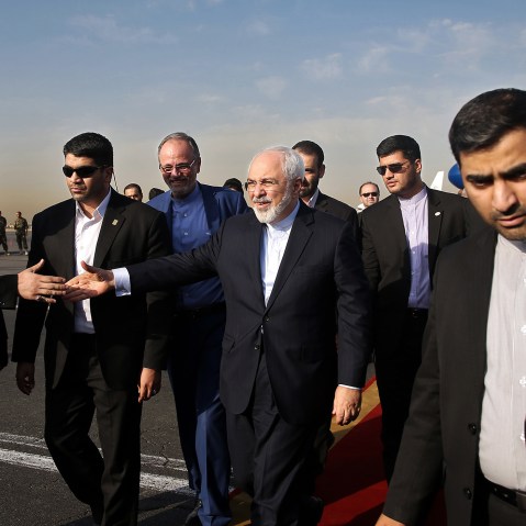 Iran's Foreign Minister Mohammad Javad Zarif, who is also Iran's top nuclear negotiator, center, shakes hands with an official upon arrival at the Mehrabad airport in Tehran, Iran, July 15, 2015. (Photo by Ebrahim Noroozi/AP)