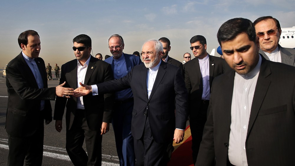 Iran's Foreign Minister Mohammad Javad Zarif, who is also Iran's top nuclear negotiator, center, shakes hands with an official upon arrival at the Mehrabad airport in Tehran, Iran, July 15, 2015. (Photo by Ebrahim Noroozi/AP)