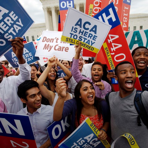 In this June 25, 2015 file photo, students cheer outside of the Supreme Court in Washington, celebrating the Supreme Court decision that the ACA may provide nationwide tax subsidies. (Photo by Jacquelyn Martin/AP)