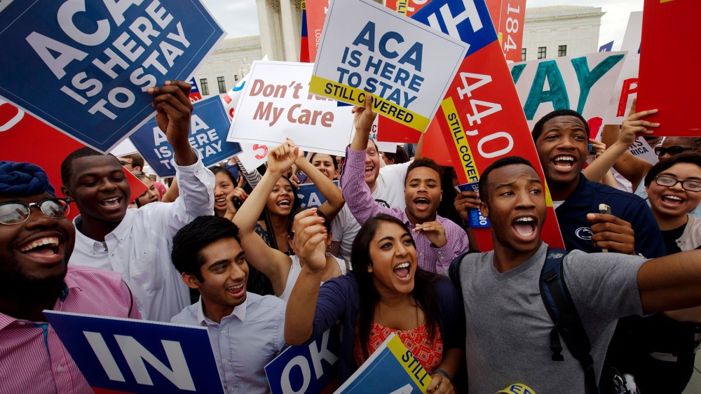 In this June 25, 2015 file photo, students cheer outside of the Supreme Court in Washington, celebrating the Supreme Court decision that the ACA may provide nationwide tax subsidies. (Photo by Jacquelyn Martin/AP)