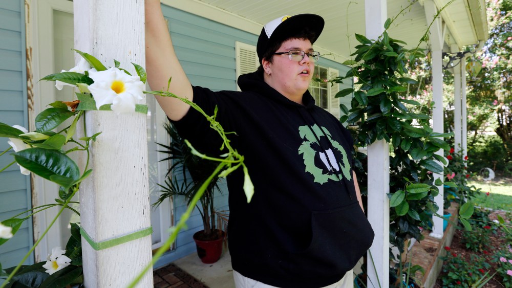 This Aug. 25, 2015 photo shows Gavin Grimm leaning on a post on his front porch during an interview at his home in Gloucester, Va. (Photo by Steve Helber/AP)