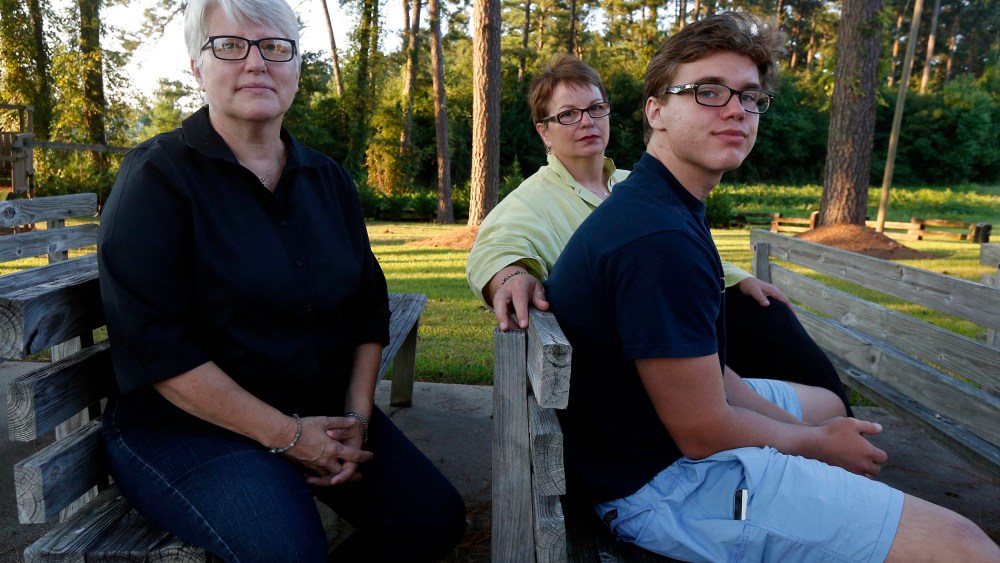 Hudson Garner, 15, right, sits outside with his mothers Kathryn Garner, and Susan Hrostowski, left, in Collins, Miss., Aug. 12, 2015. (Photo by Rogelio V. Solis/AP