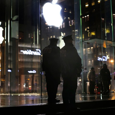 New York police officers stand outside the Apple Store on Fifth Avenue while monitoring a demonstration, Feb. 23, 2016, in New York. (Photo by Julie Jacobson/AP)