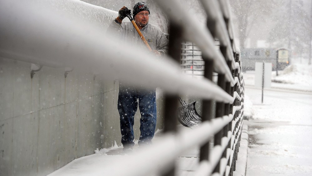 Dan Schumacher clears off the sidewalk outside of the Sioux Falls, VA Medical Center in Sioux Falls, S.D., Nov. 30, 2015. (Photo by Jay Pickthorn/The Argus Leader/AP)
