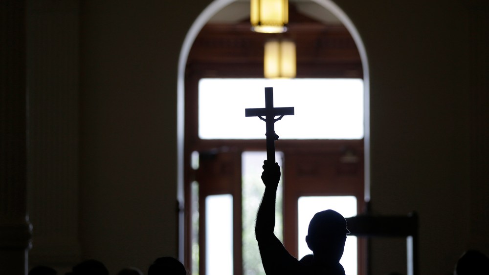 A man carries a cross. (Photo by Eric Gay/AP)