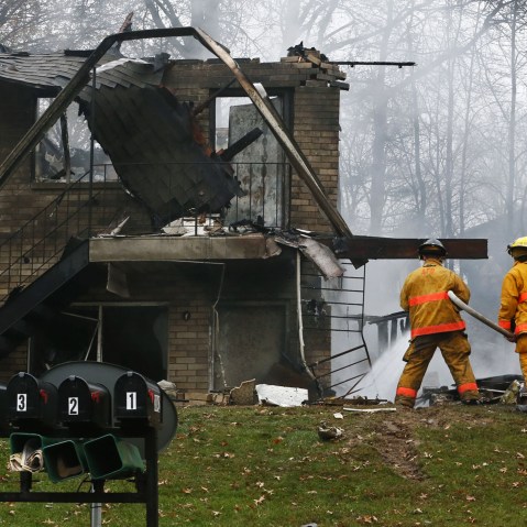 Firefighters work at the scene where authorities say a small business jet crashed into an apartment building in Akron, Ohio, Tuesday, Nov. 10, 2015. (Photo by Ed Suba Jr./Akron Beacon Journal/AP)